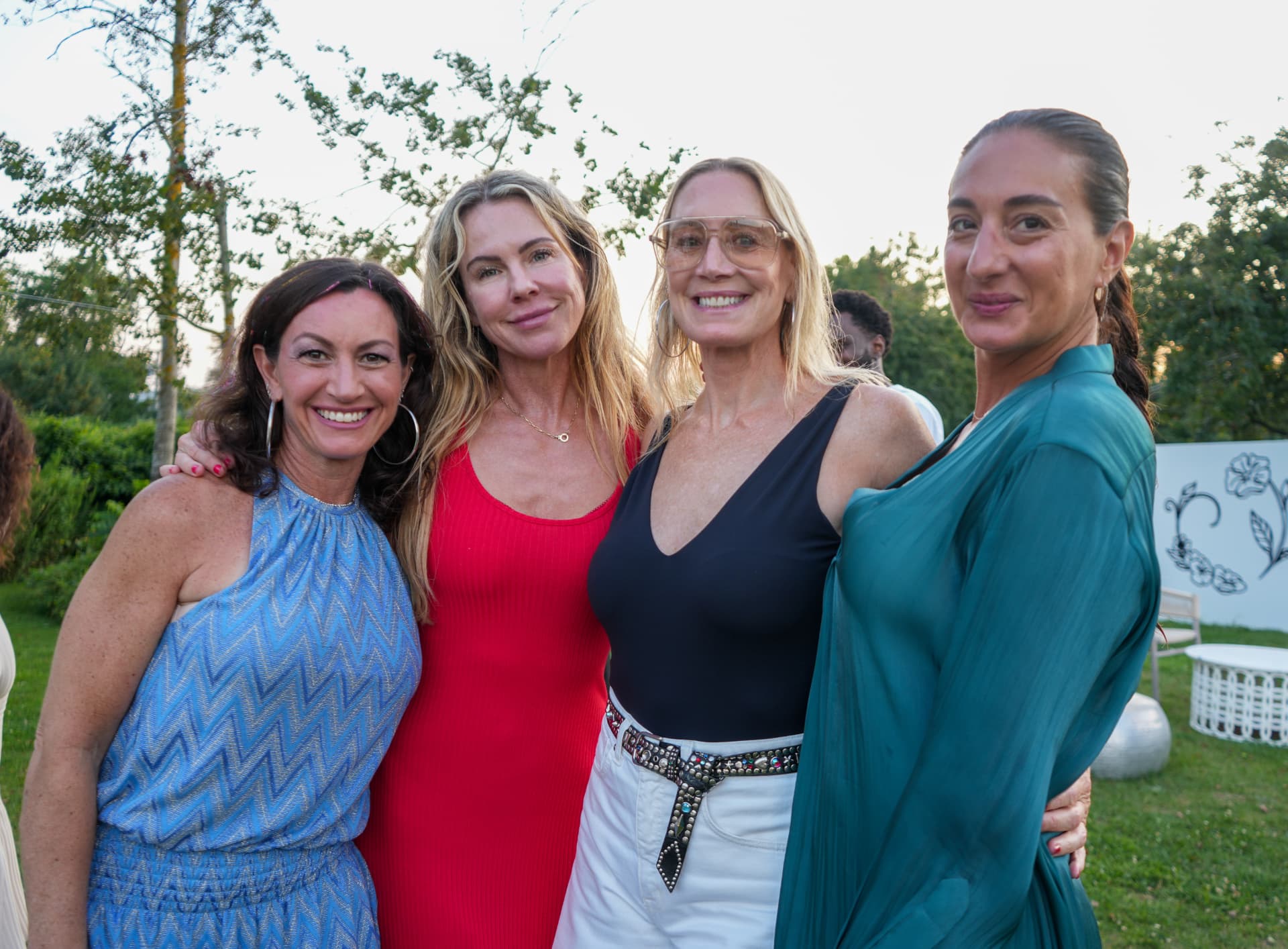 Four guests together for a portrait on the lawn at golden hour