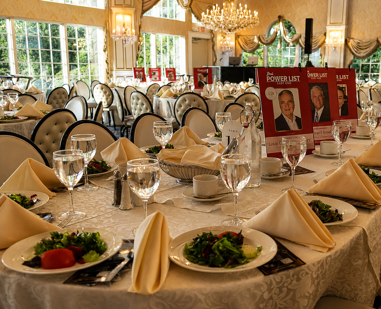 Set table with honoree cards, salads and stemware in the chandelier-lit ballroom