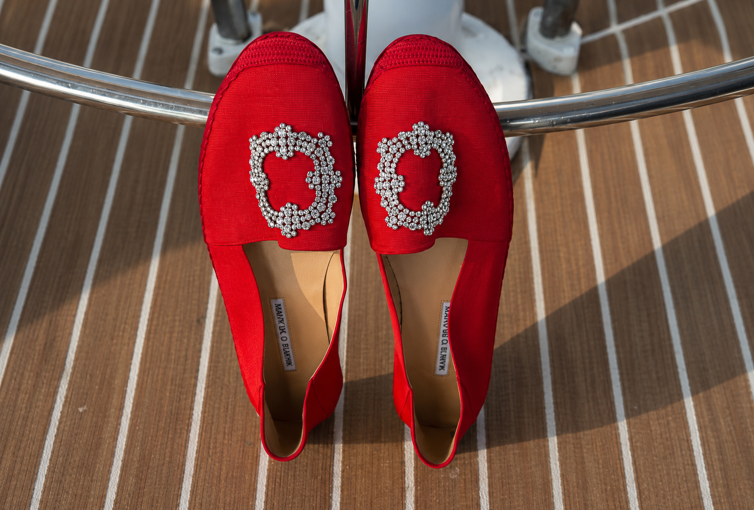 Red satin flats styled on the teak deck