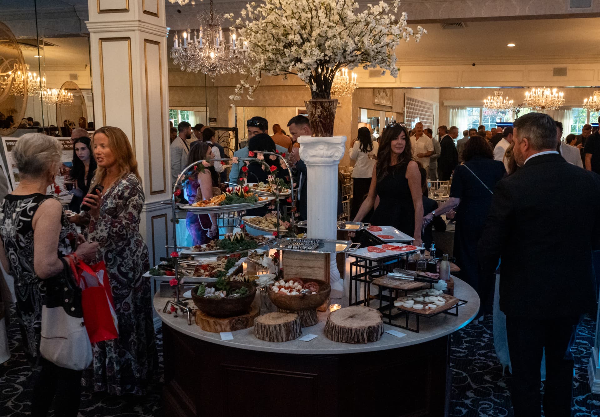 Guests gathered around the blossom-topped grazing station during the reception