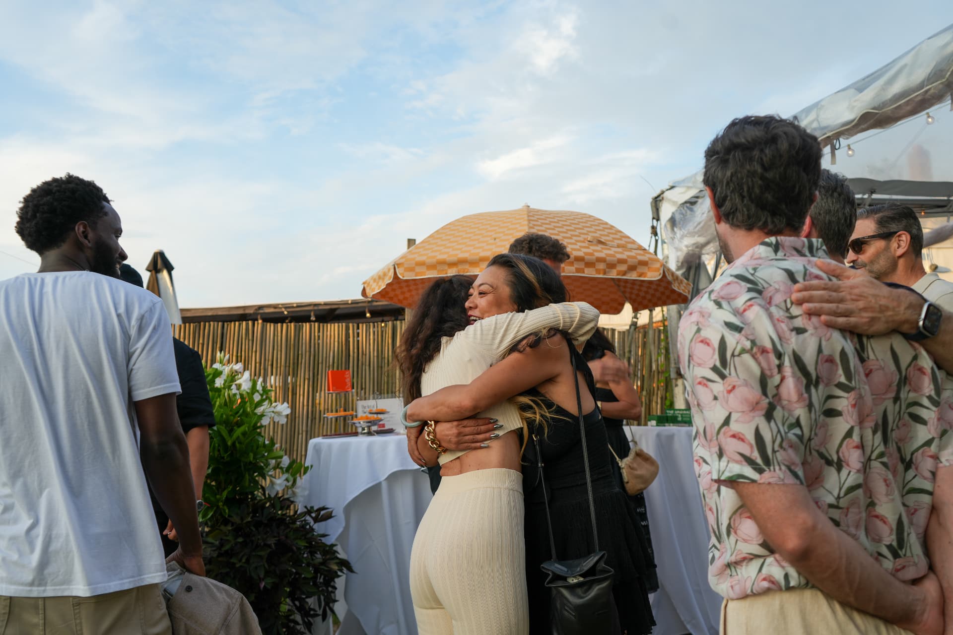 Two guests embracing warmly during the golden-hour reception