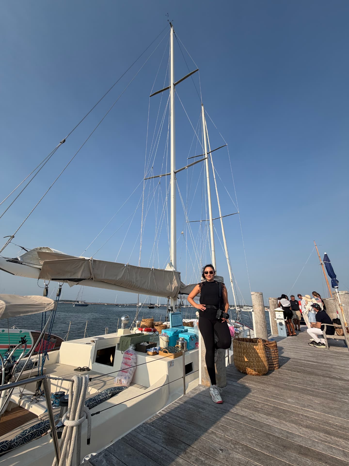 Laura Hidrobo on location with her camera beside a sailing yacht