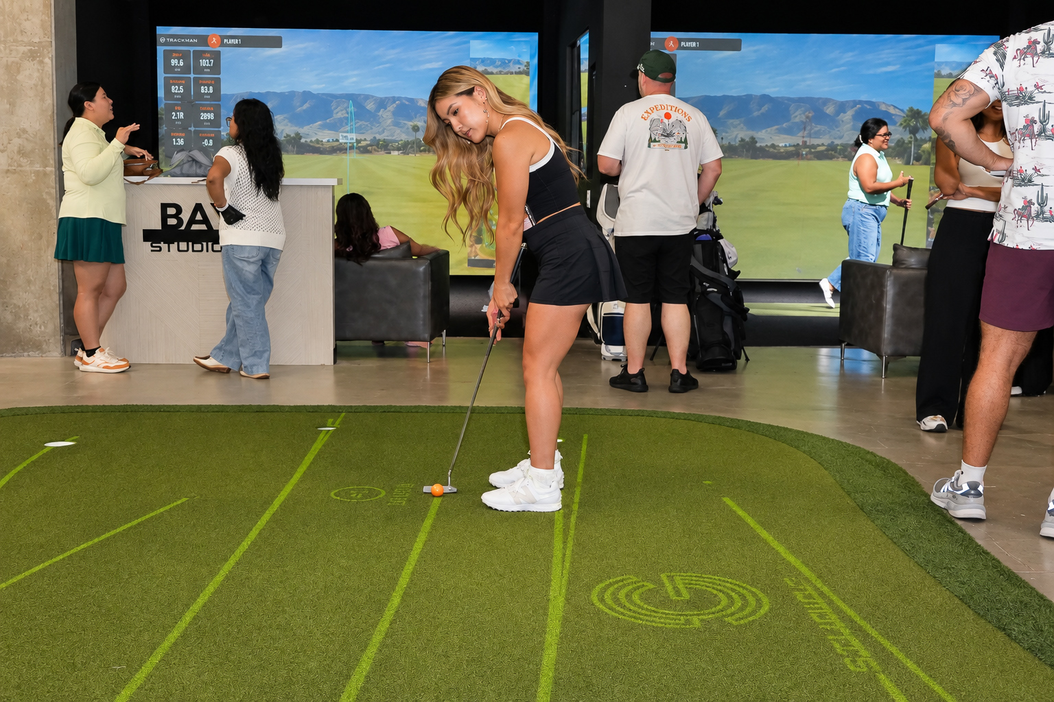 Attendee putting while guests take part in the event