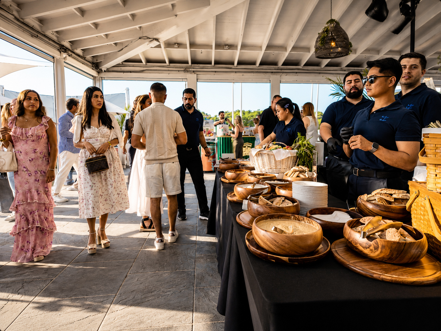 Guests moving past the culinary station with wooden serving bowls and breads