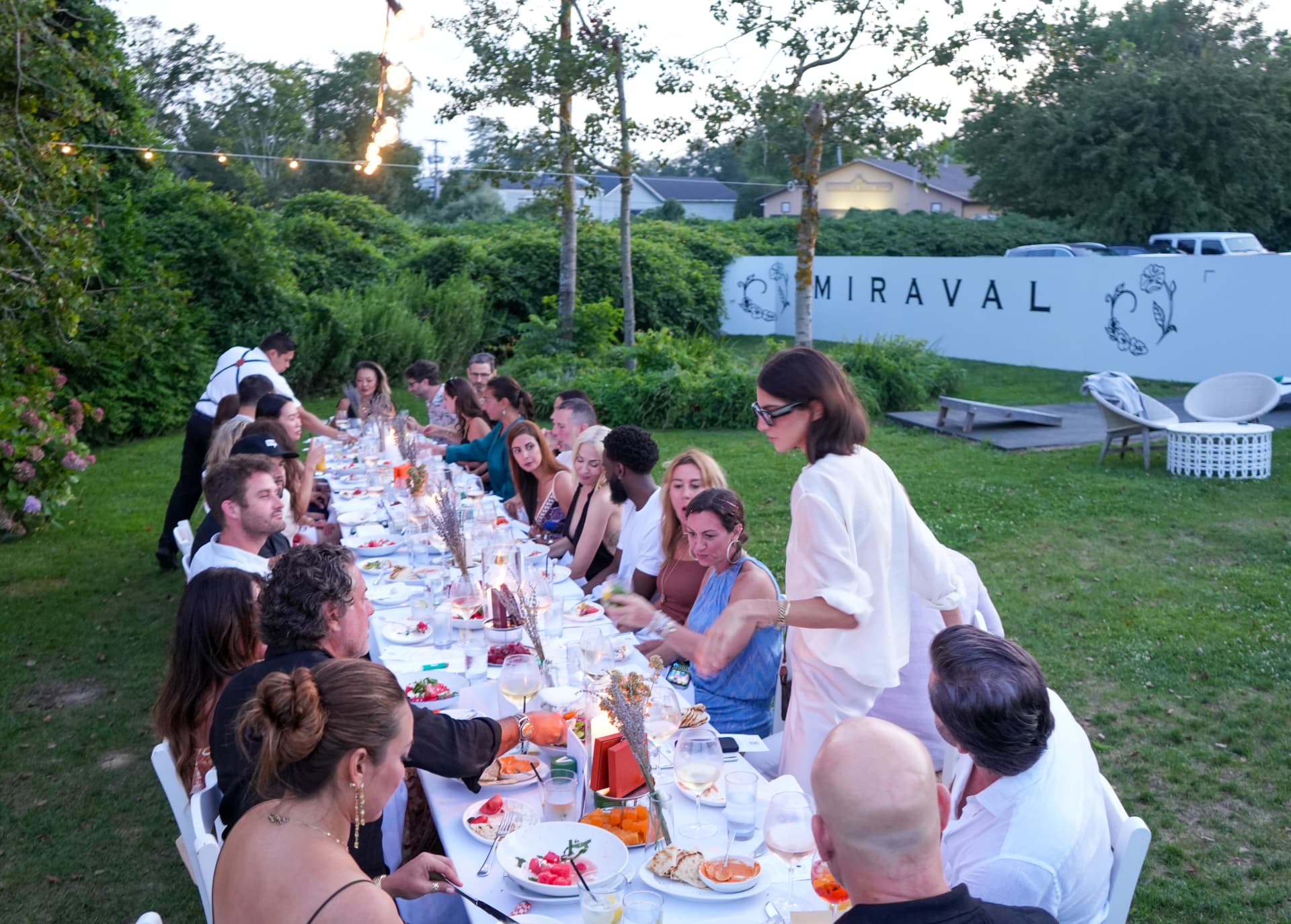 Elevated view of the long candlelit dinner table with the Miraval wall beyond
