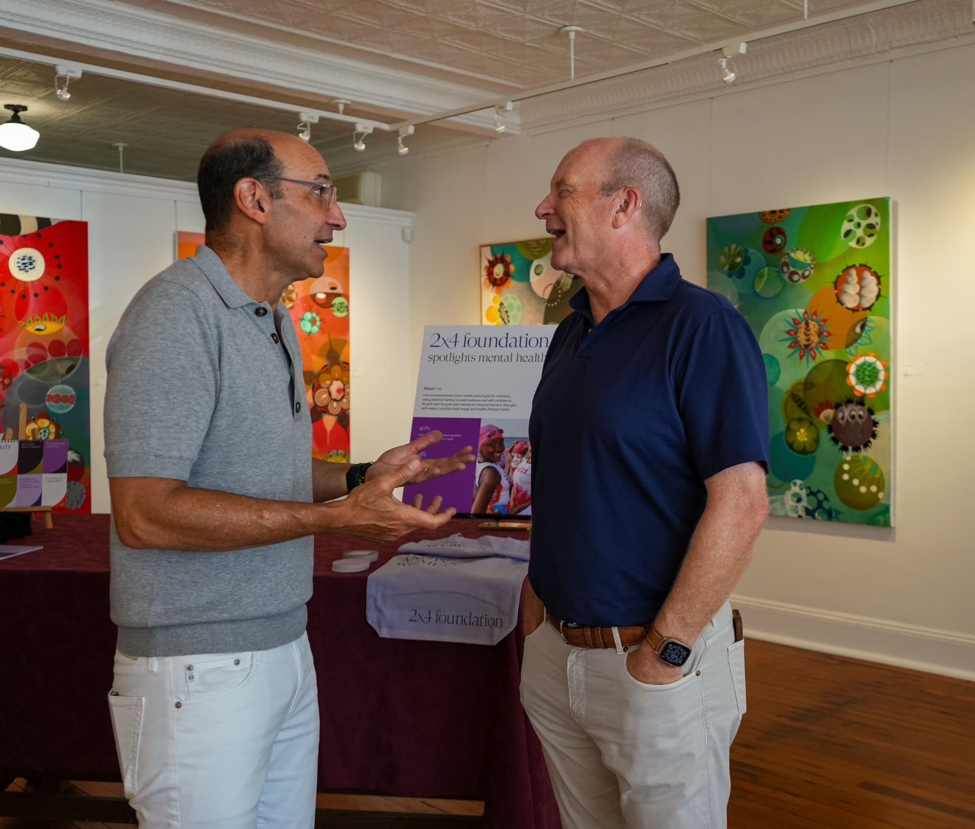Two guests in conversation beside the 2x4 Foundation display table