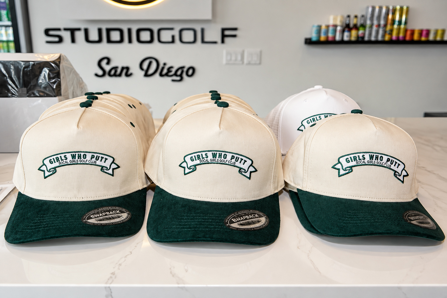 Embroidered event caps lined up on a marble counter