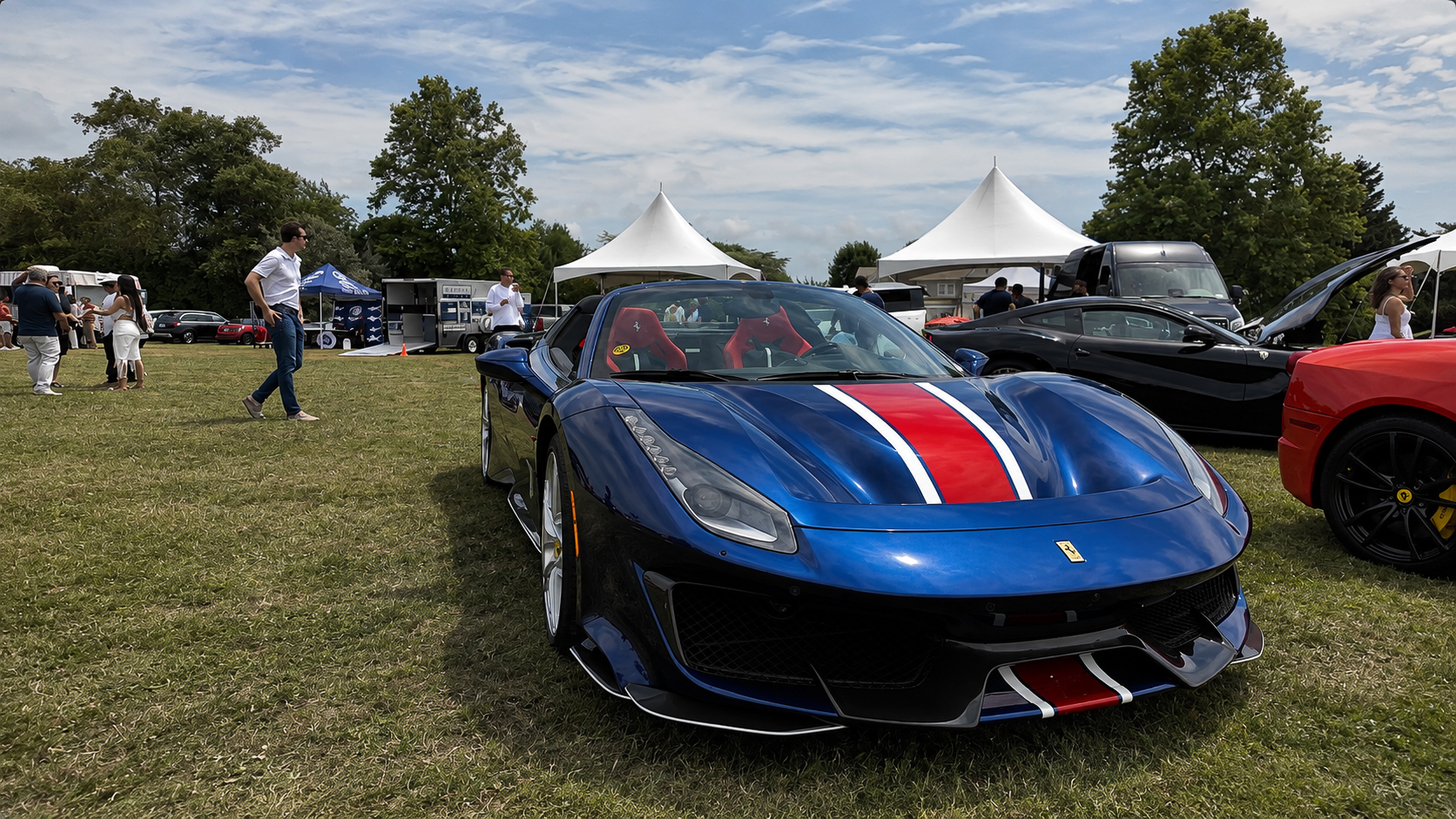 Blue Ferrari 488 Pista Spider with racing stripe parked on the grass