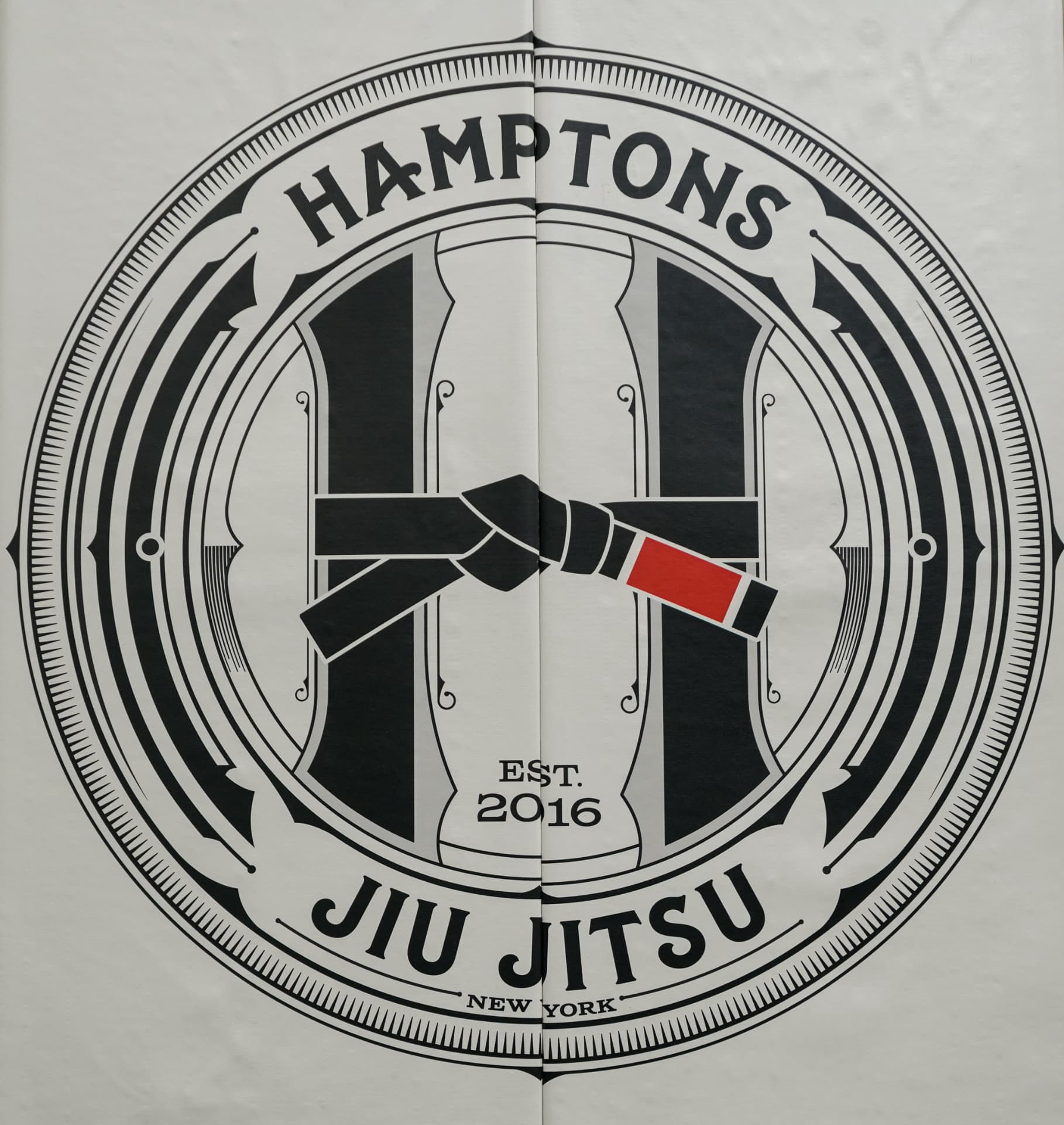 Hamptons Jiu Jitsu crest banner hanging inside the training space