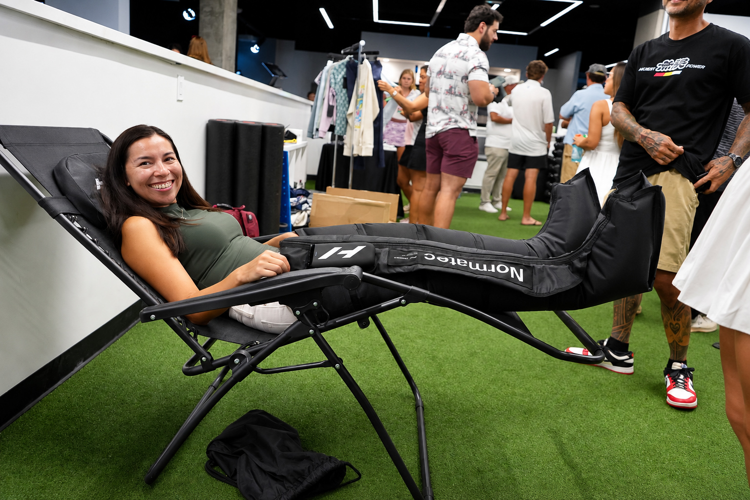 Guest relaxing in recovery compression boots during the event