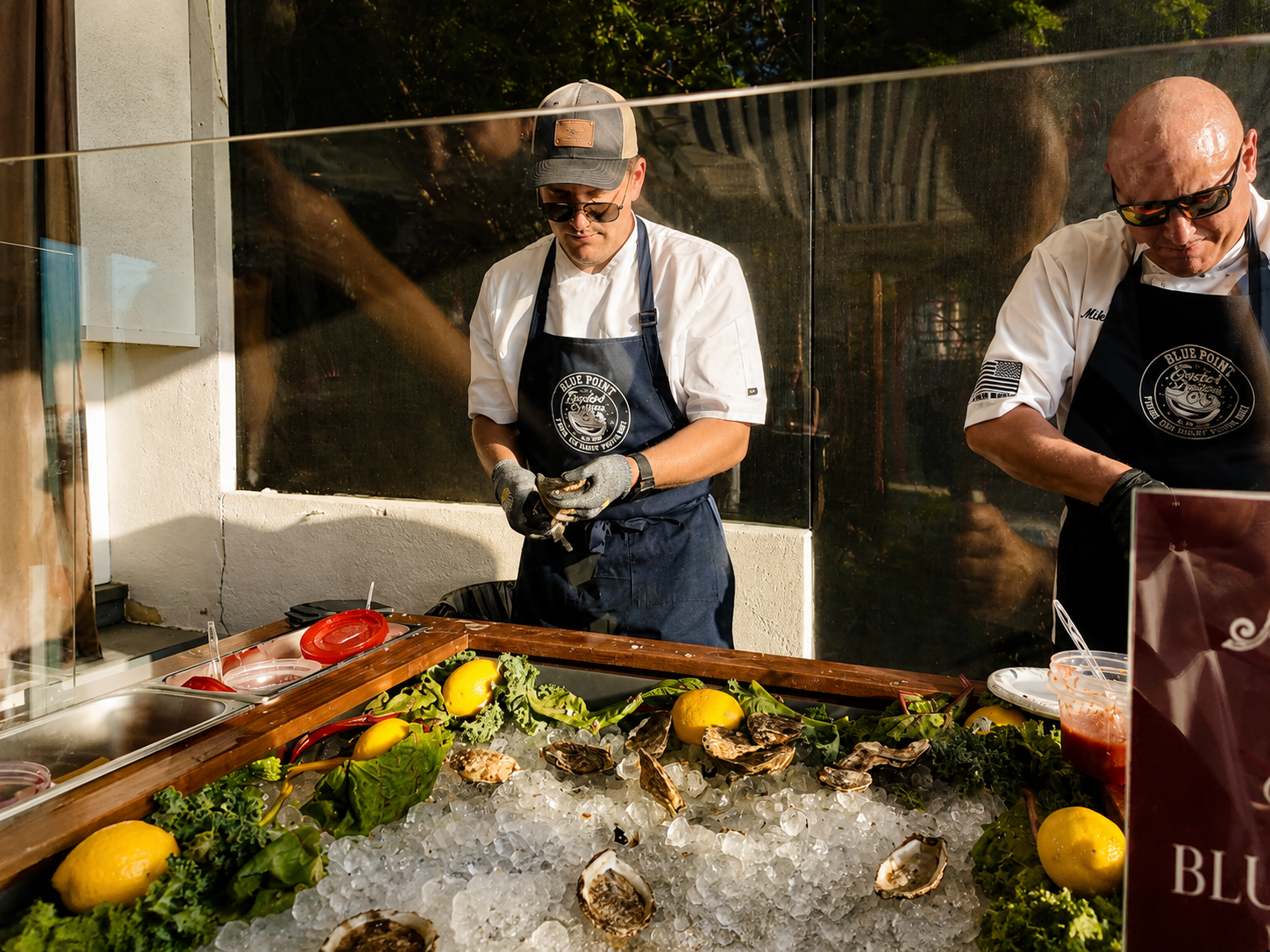 Blue Point Oyster Company shuckers preparing oysters on ice at golden hour