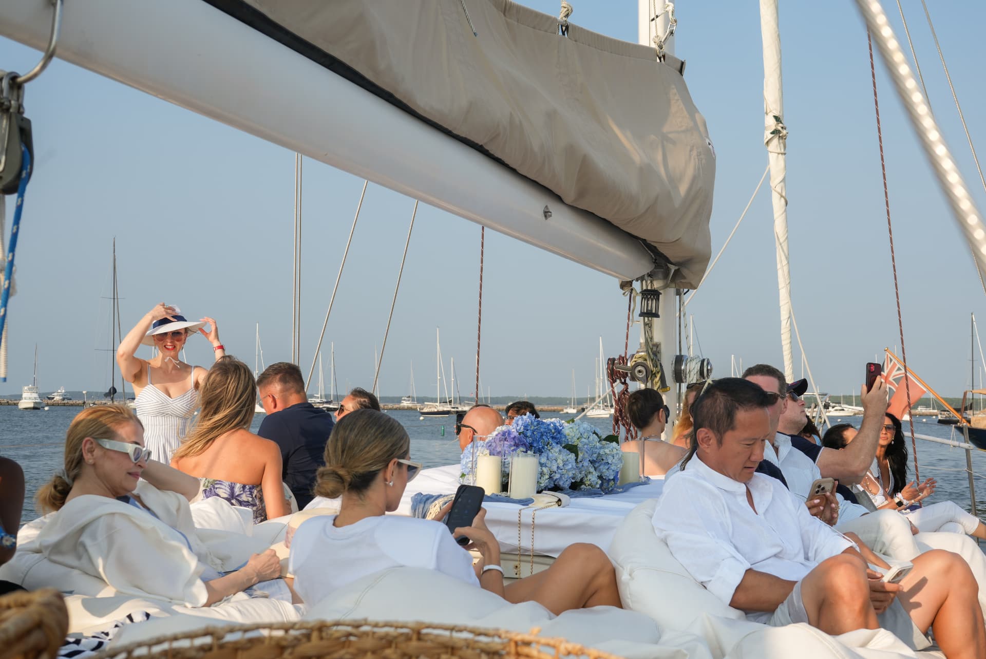 Guests relaxing on deck cushions under the boom in the harbor