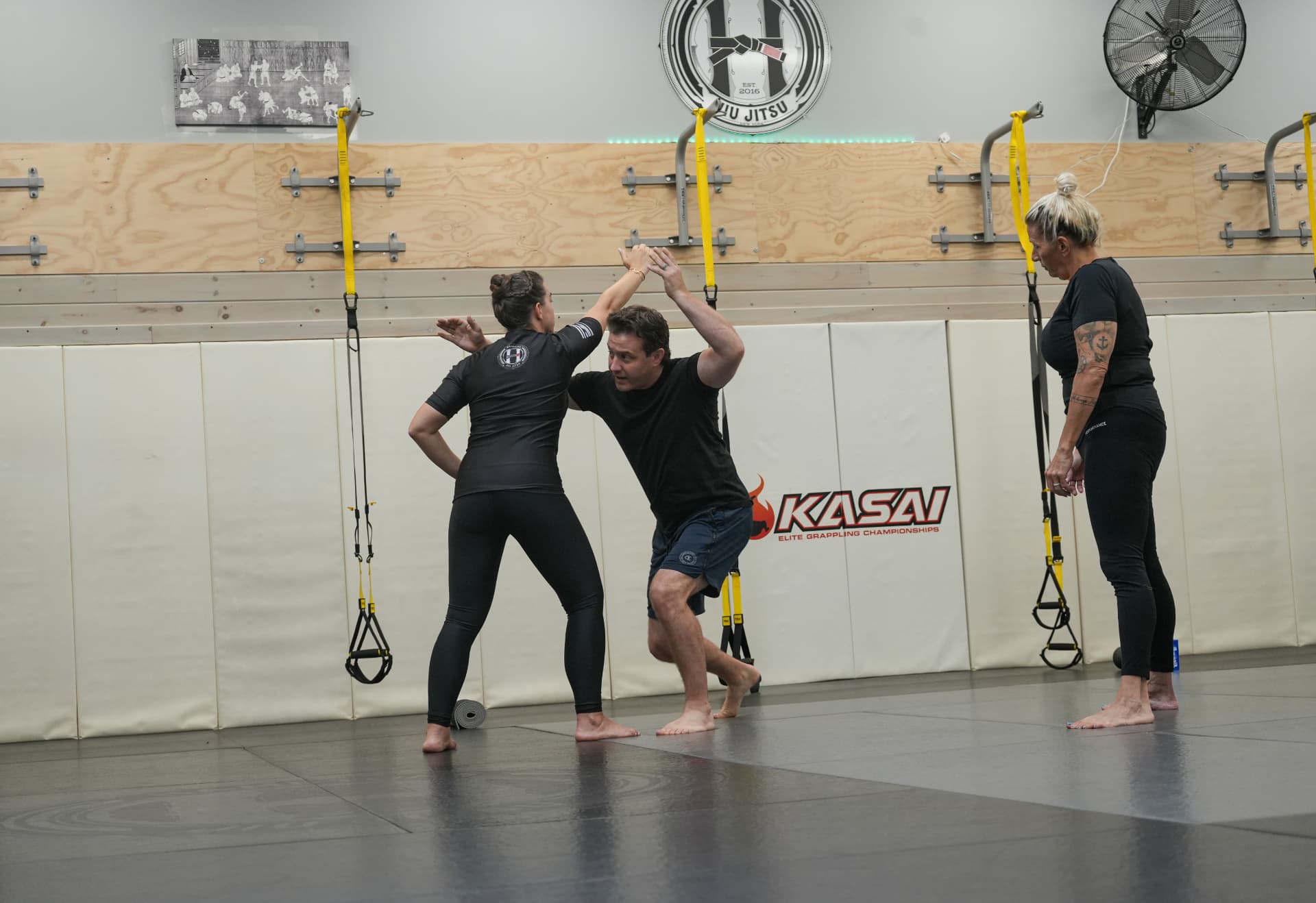 Jiu jitsu instructor demonstrating a self-defense technique with a participant