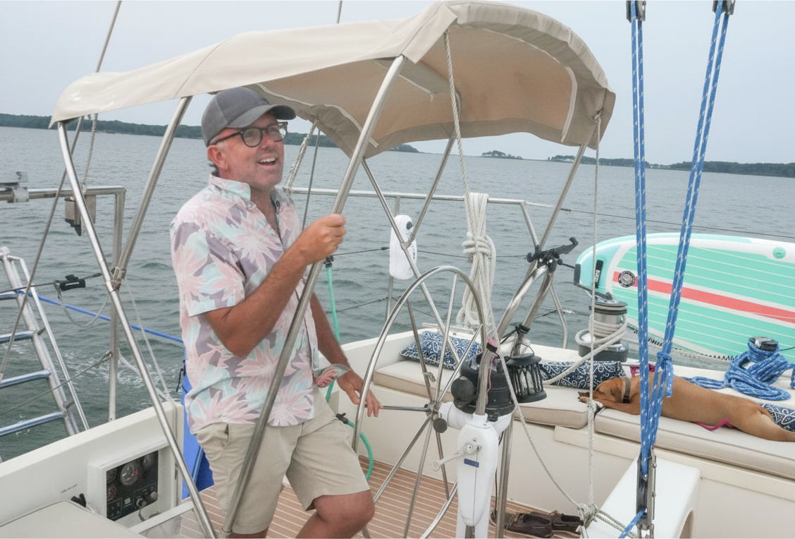 Captain at the helm under the bimini with the harbor behind