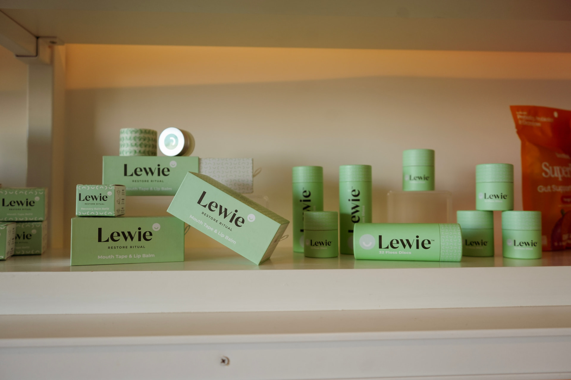 Green wellness product packaging arranged on a softly lit shelf