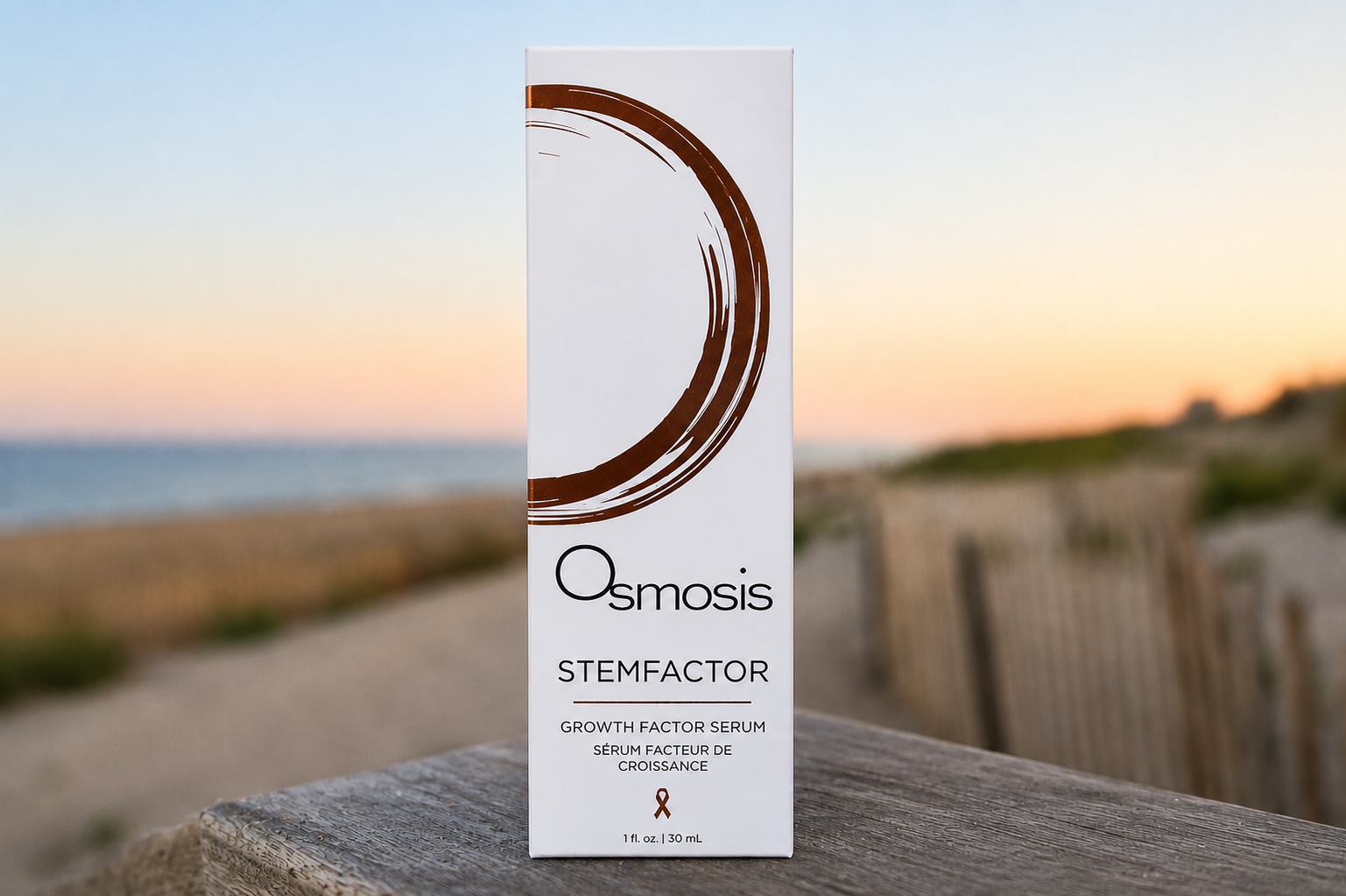 Osmosis StemFactor serum carton on weathered wood at sunset by the dunes