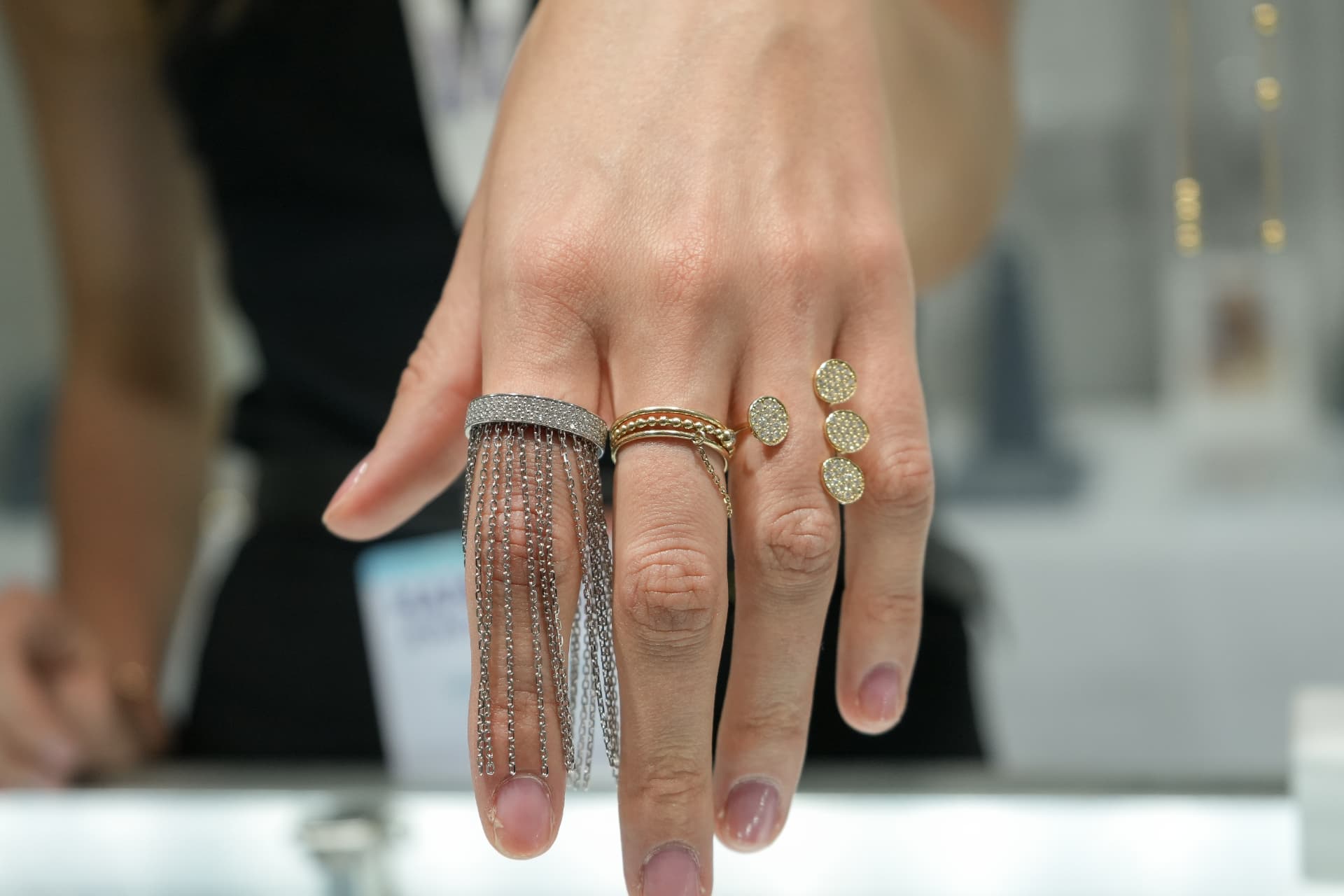 Hand wearing a silver fringe statement ring and fine gold pavé jewelry