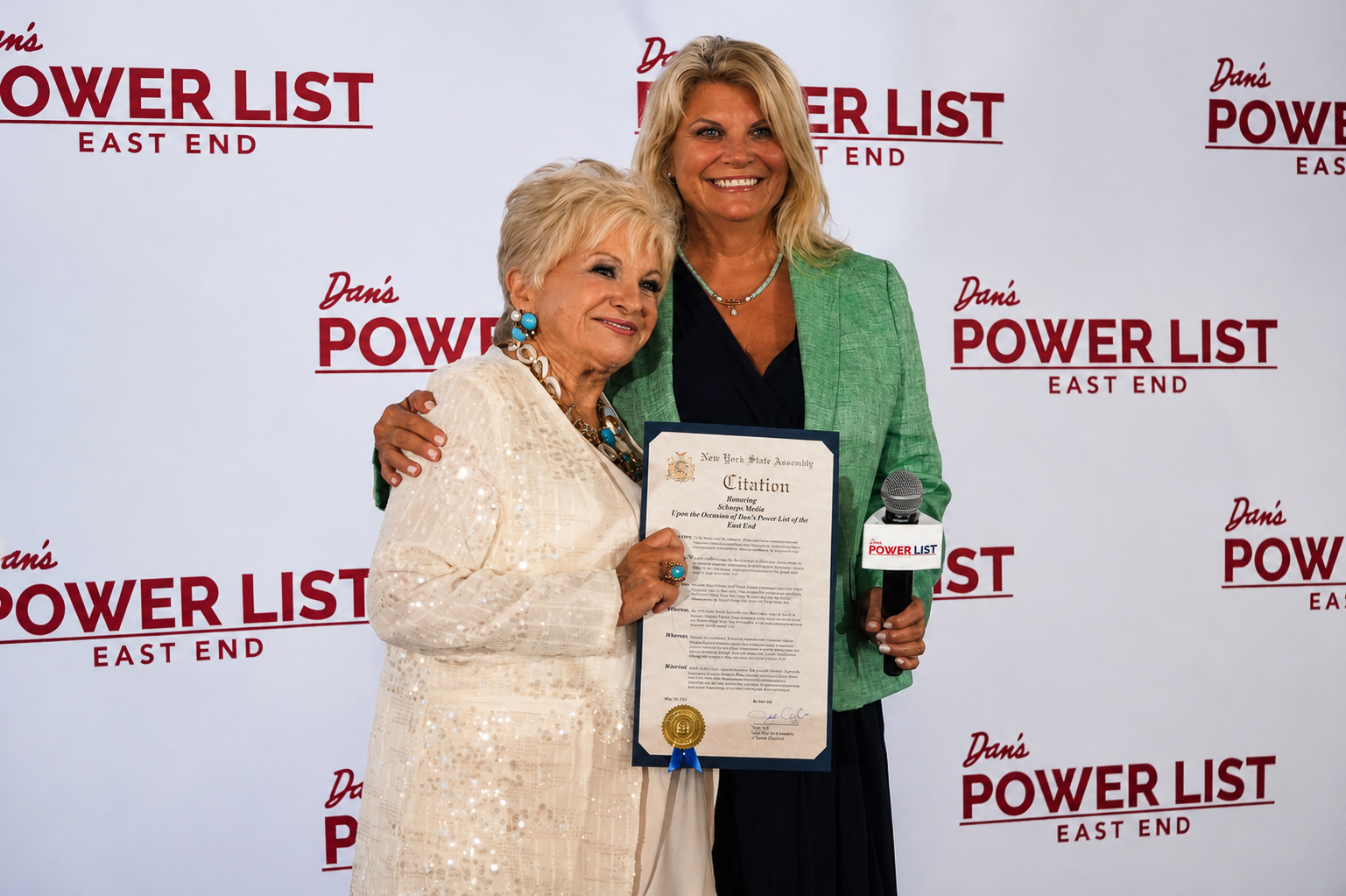 Honoree and host with a New York State Assembly citation at the Power List backdrop