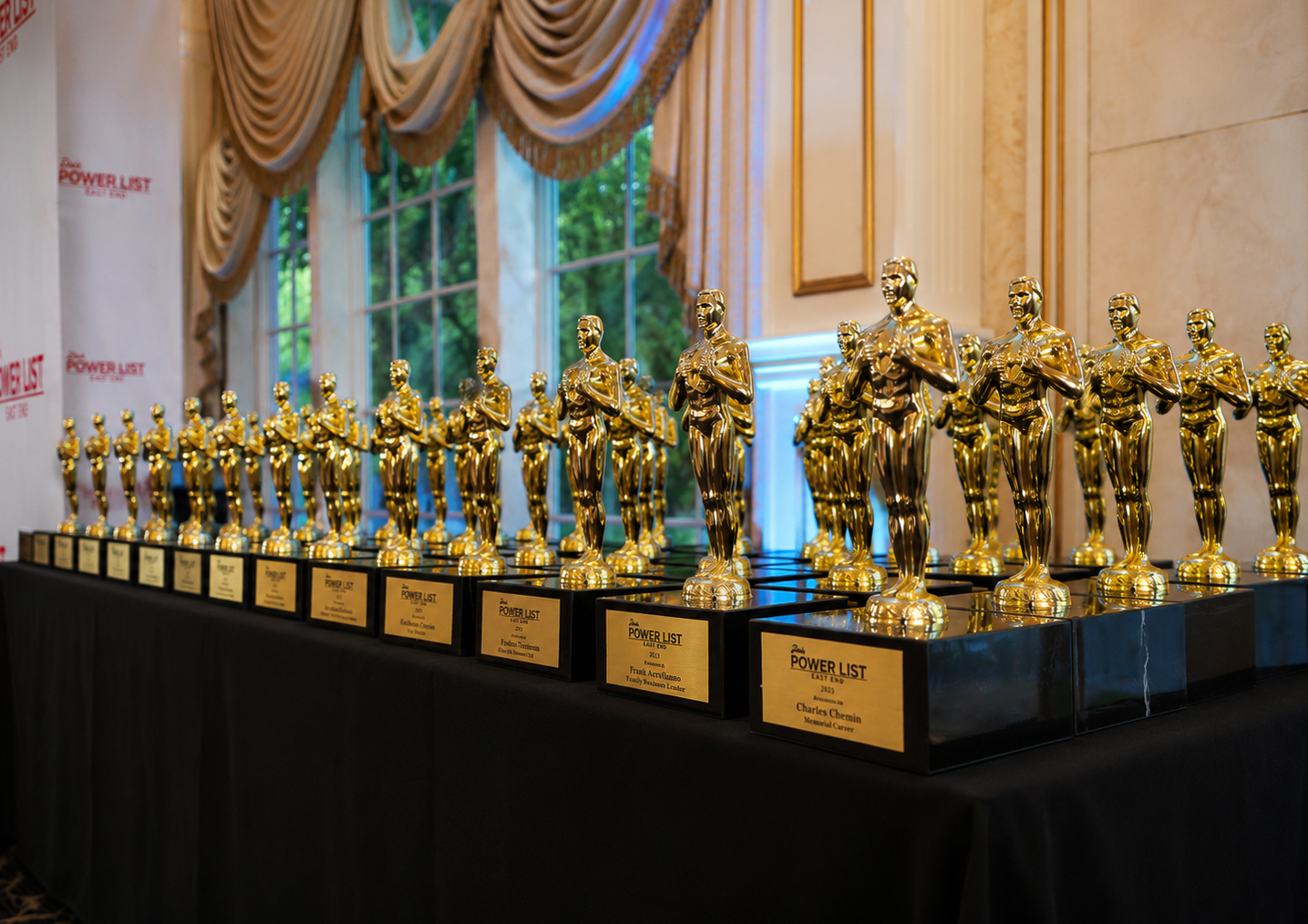 Row of engraved Dan's Power List awards lined up on the presentation table