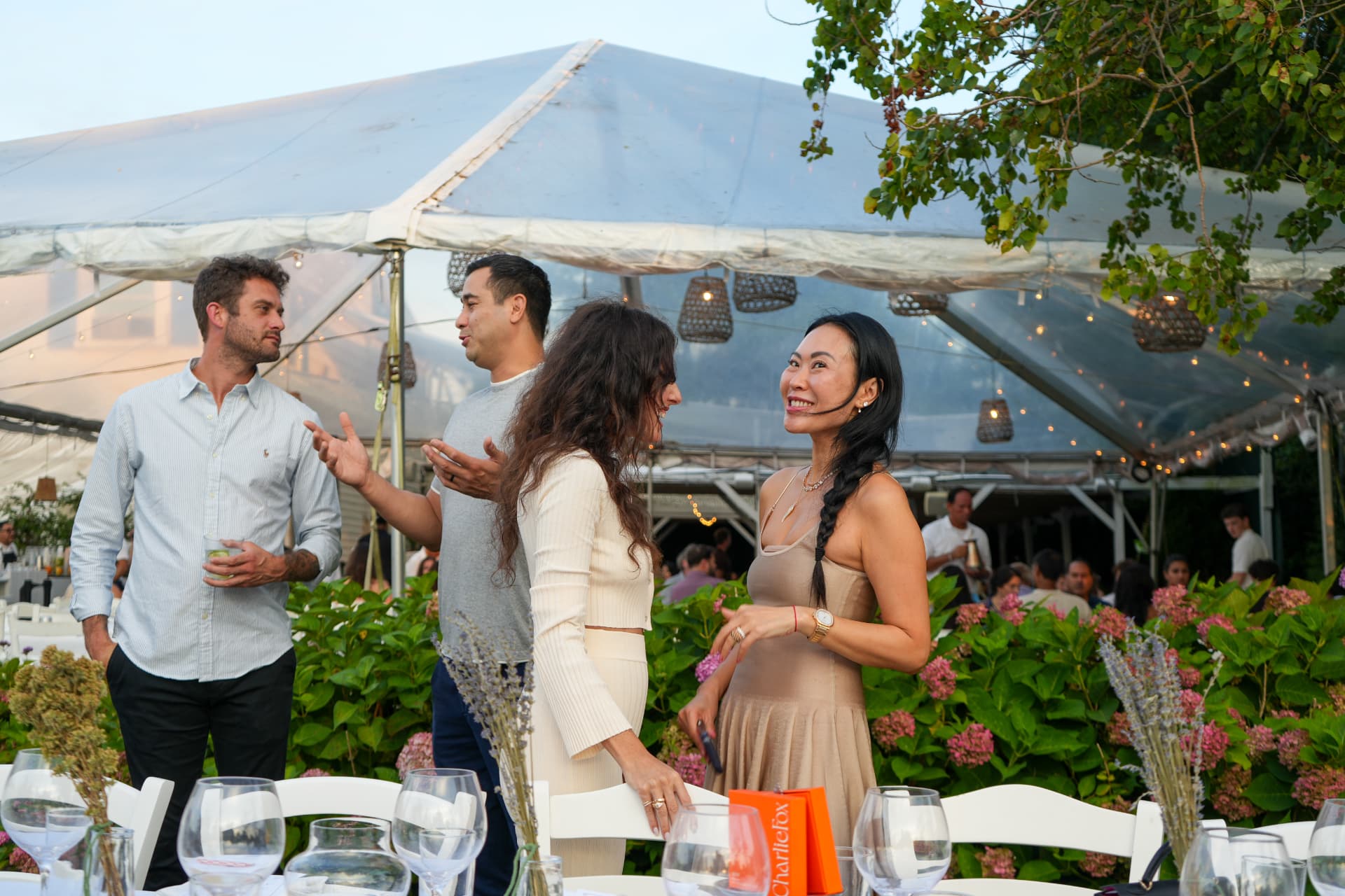 Guests in conversation beneath the tent during cocktail hour