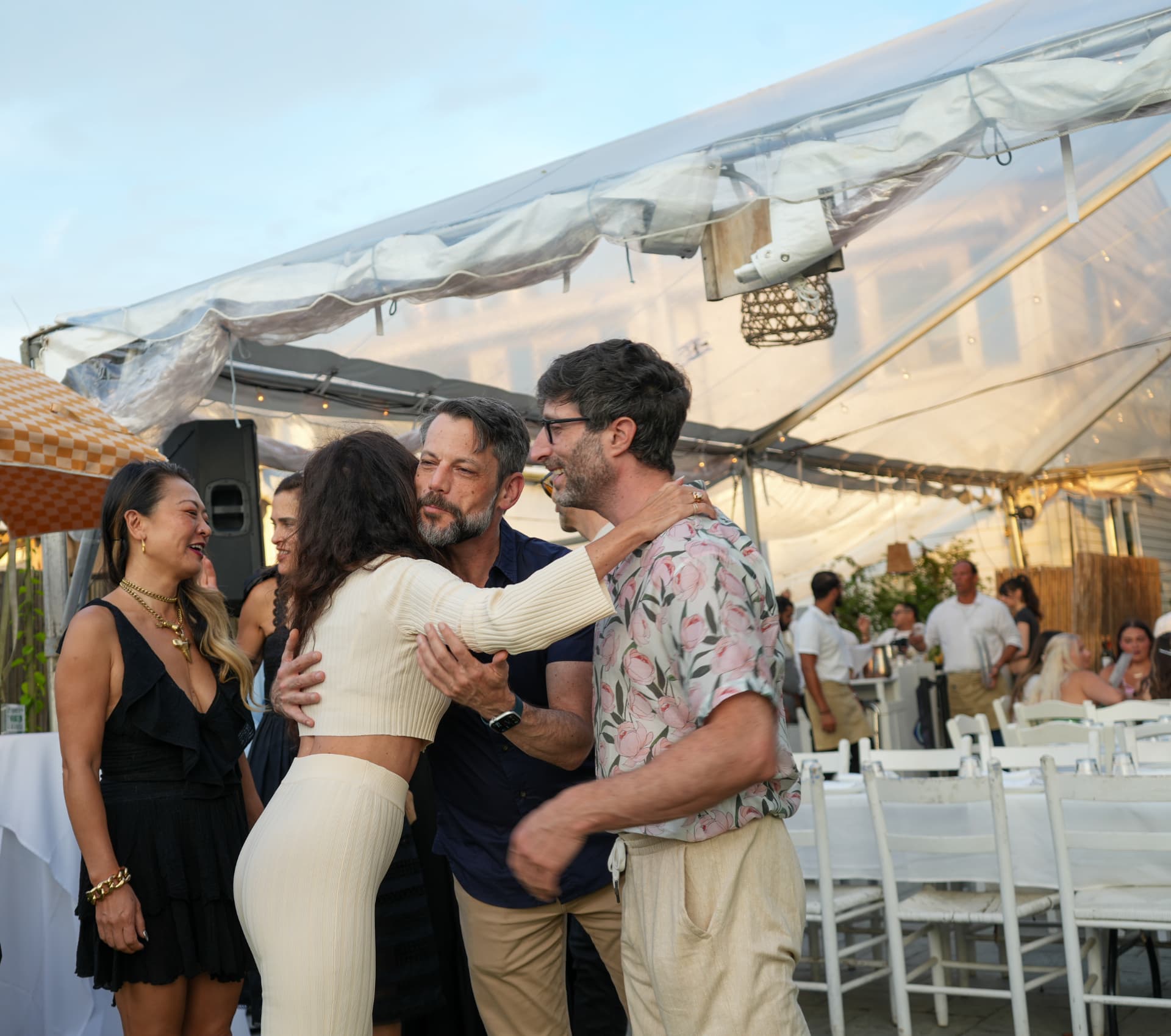 Guests embracing and mingling beneath the event tent