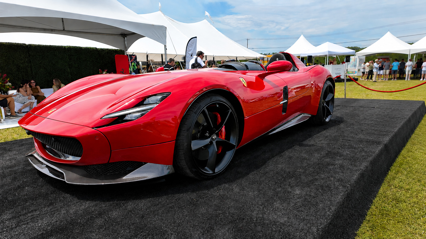 Red Ferrari Monza SP1 displayed on a platform behind a red rope