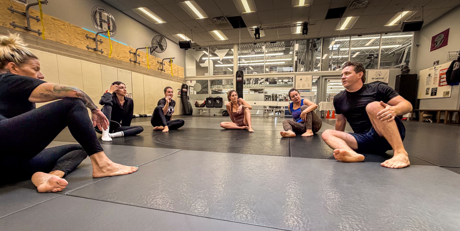 Class seated on the mats listening during the wellness discussion